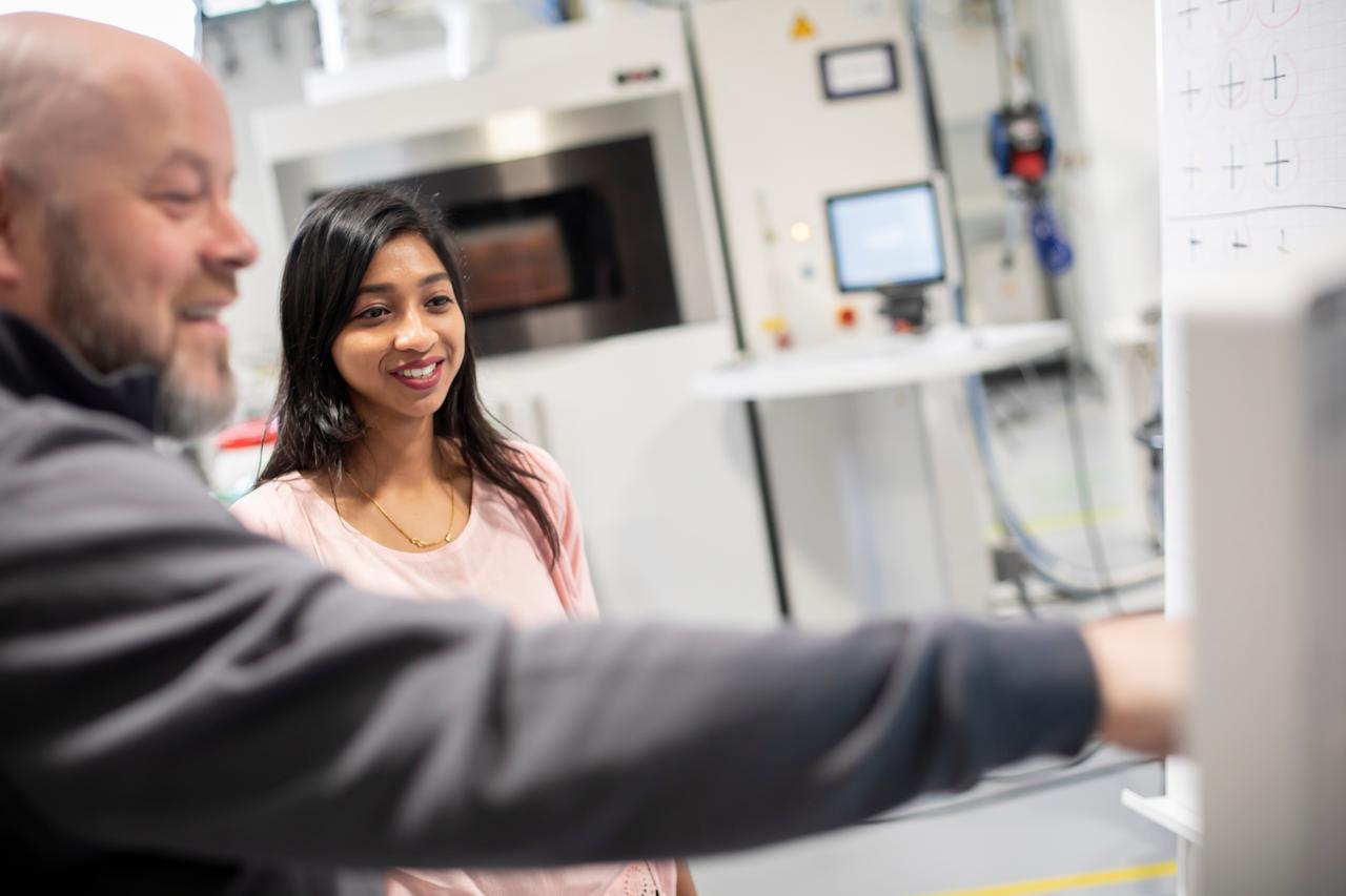 A man explaining something to a girl in a warehouse.