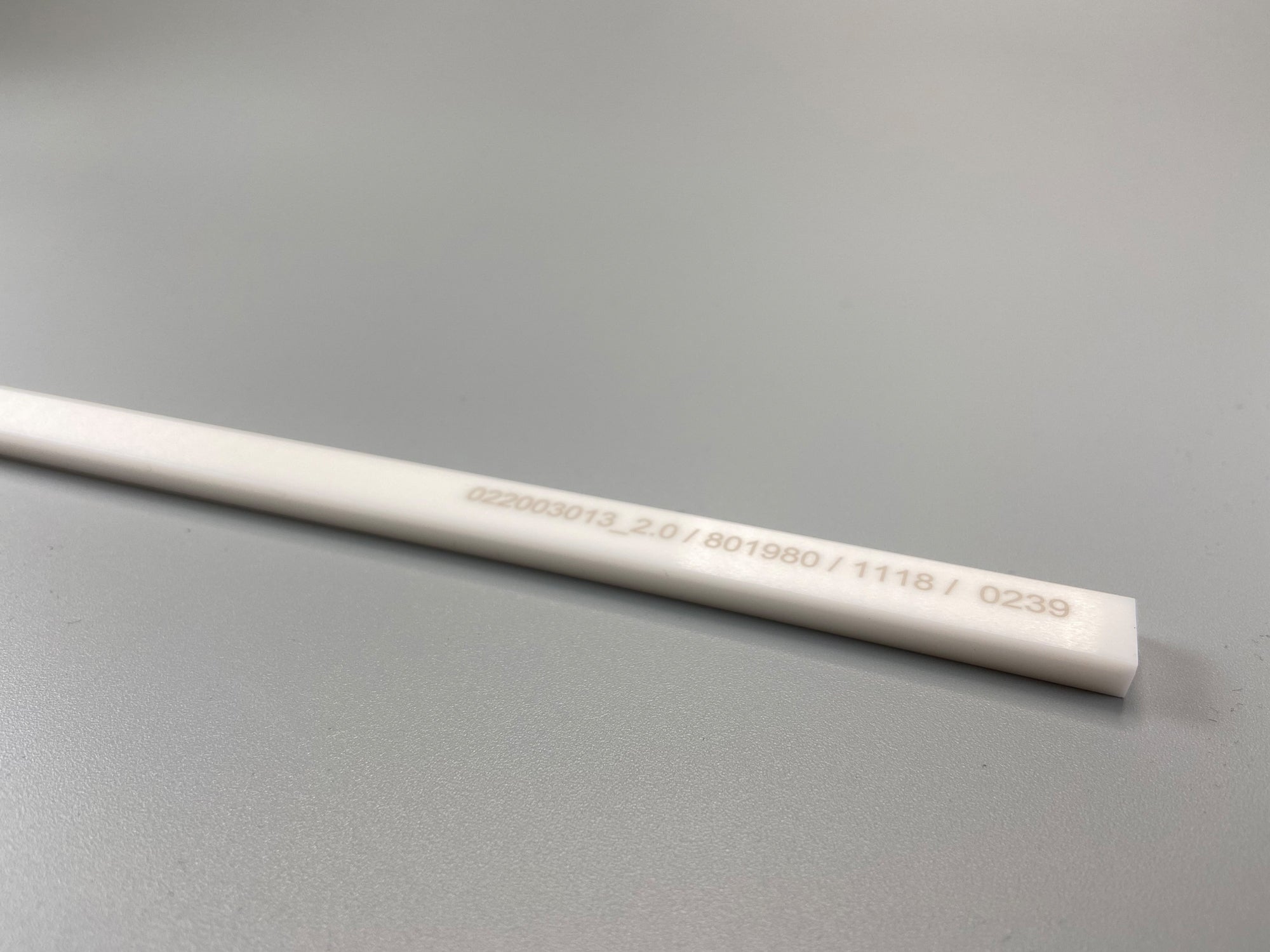 Top view of a white ceramic recoater blade.