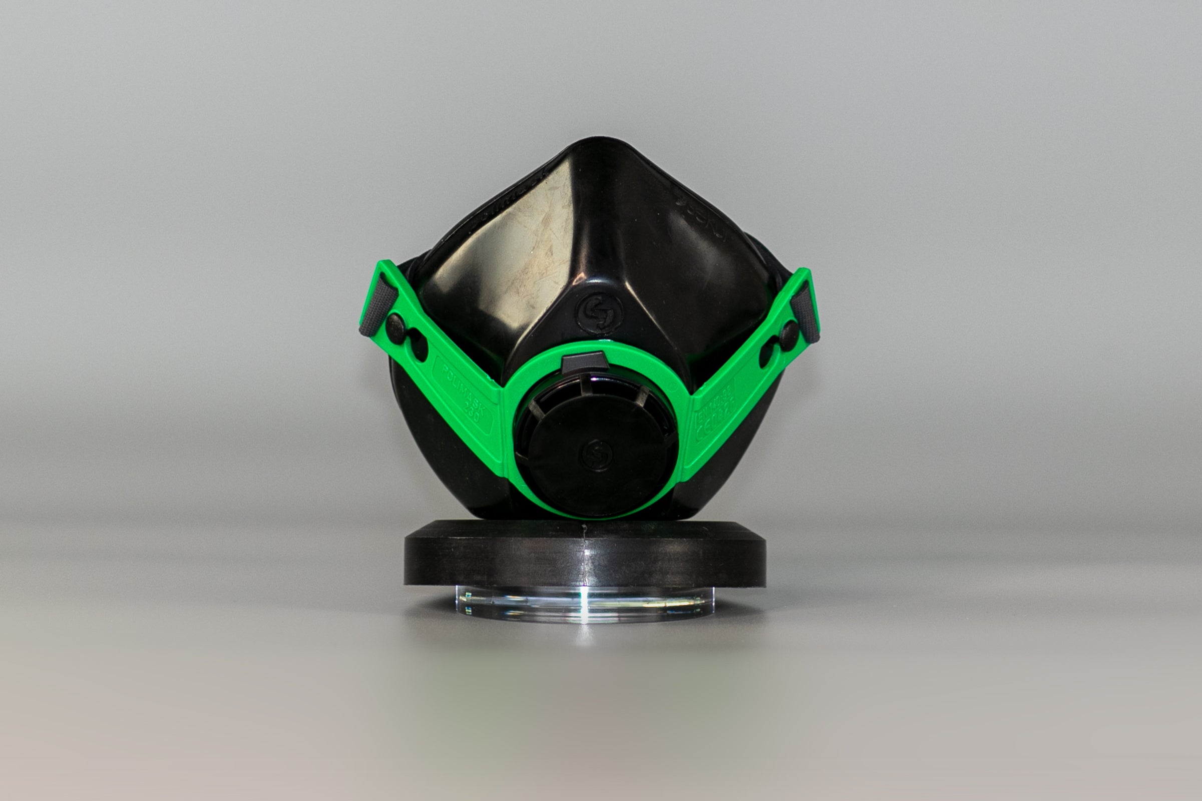 Front view of a black and green protective mask.