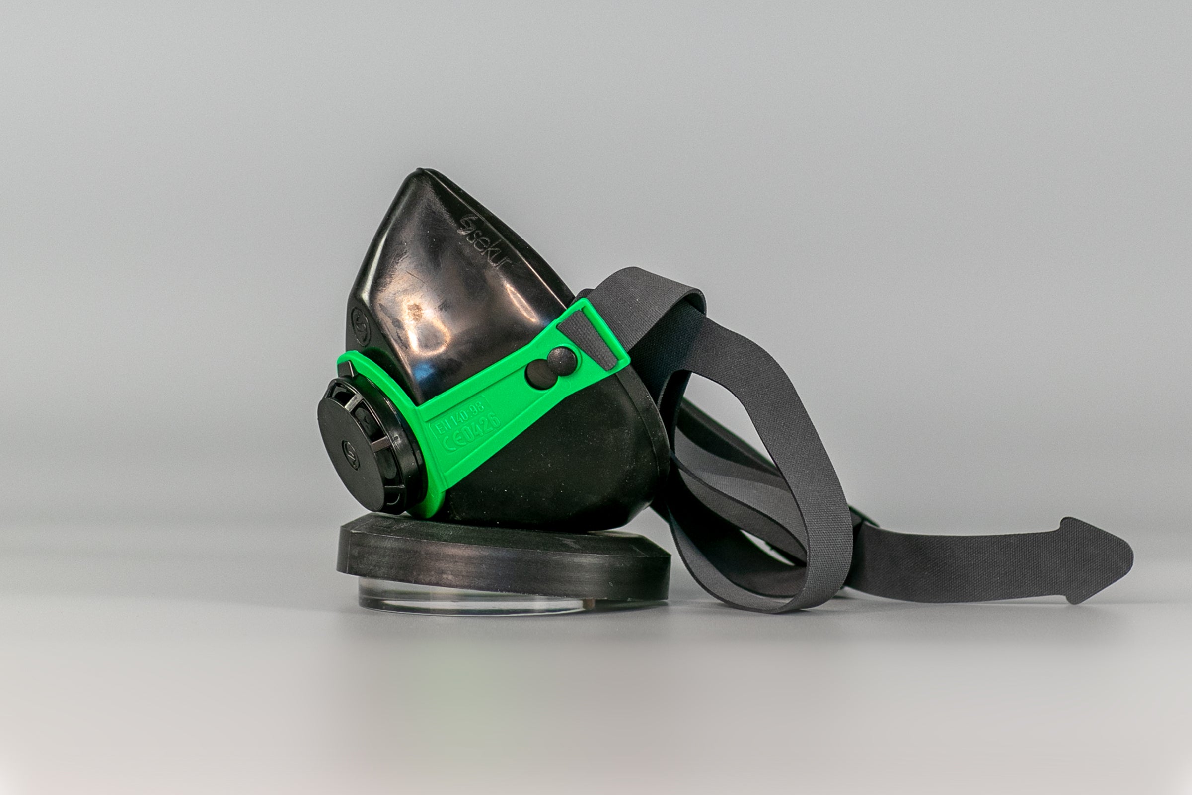 Side view of a black and green protective mask.