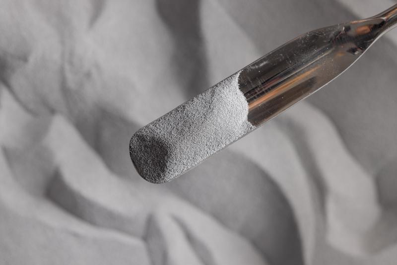 Spoonful of white polymer powder.