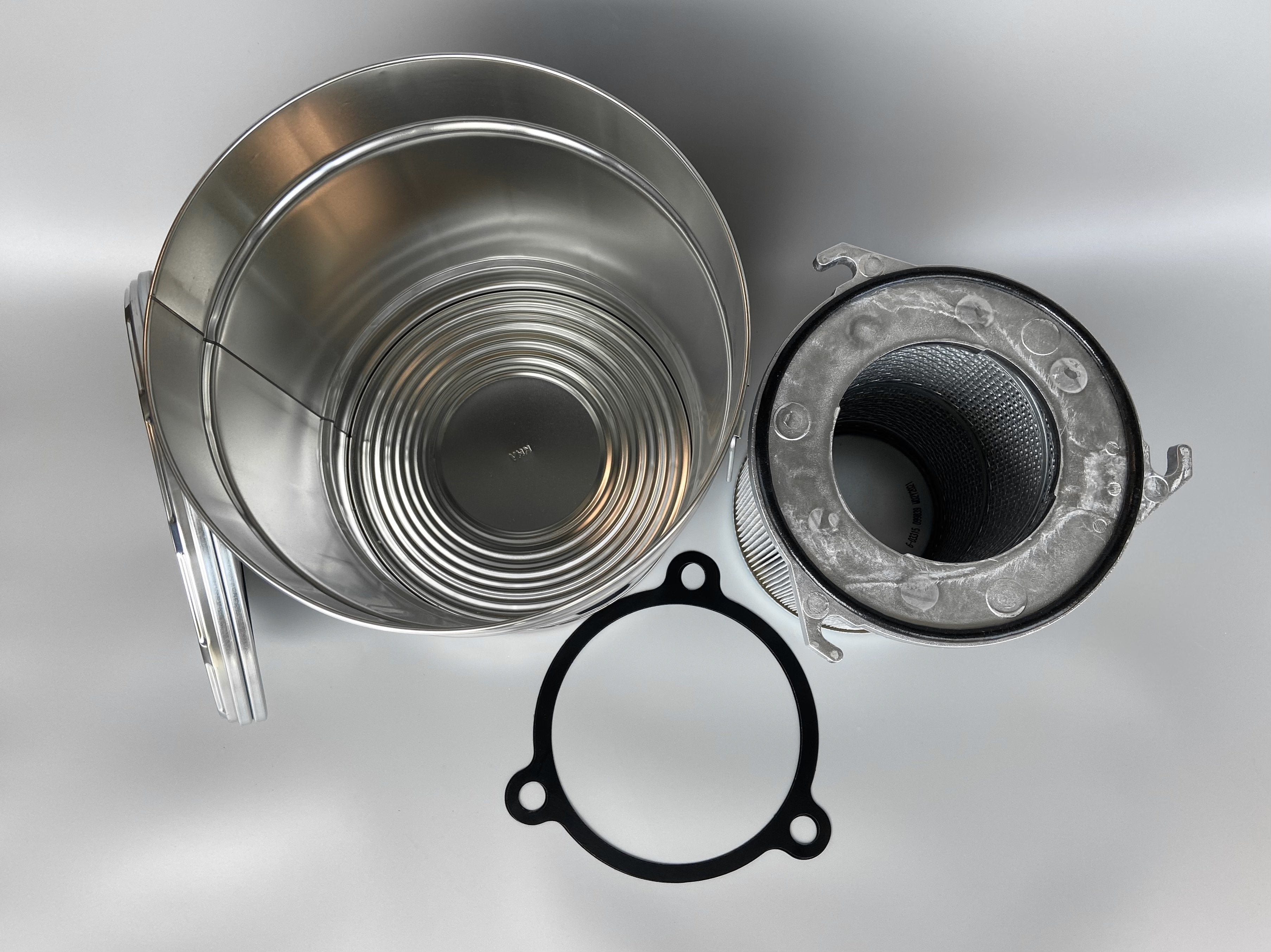 Photo containing the components of the kit: F9 filter cartridge, transport container, PTFE seal (top view).