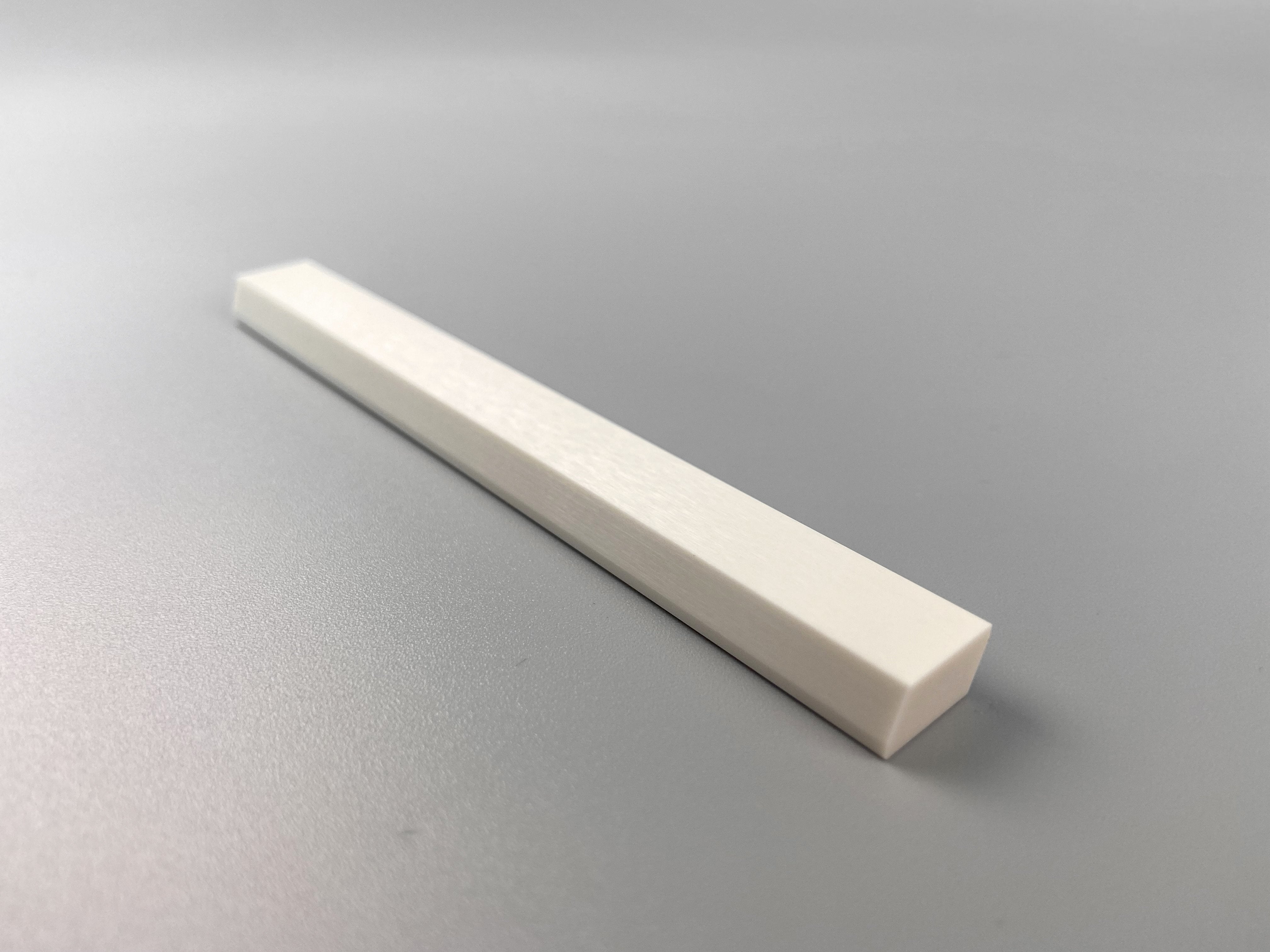 Front view of a whte ceramic recoater blade.